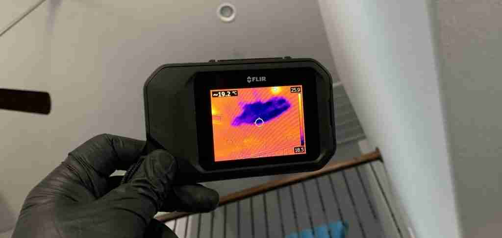 Thermal imaging camera being used to detect water in drywall