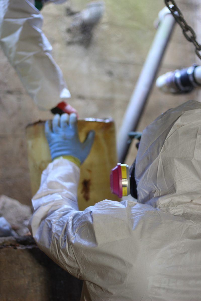 man in a hazmat suit cleaning a biohazard area