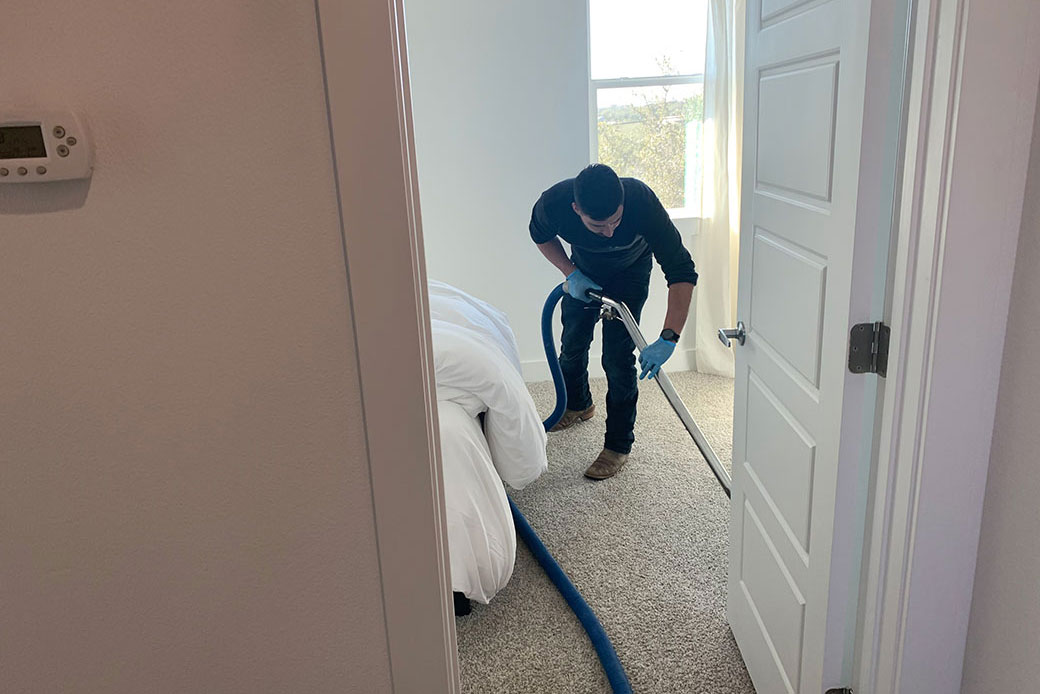 Chris moreno extracting water from a carpet with an extraction wand