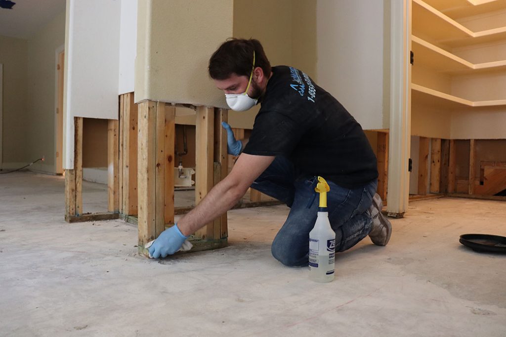Worker cleaning wall studs