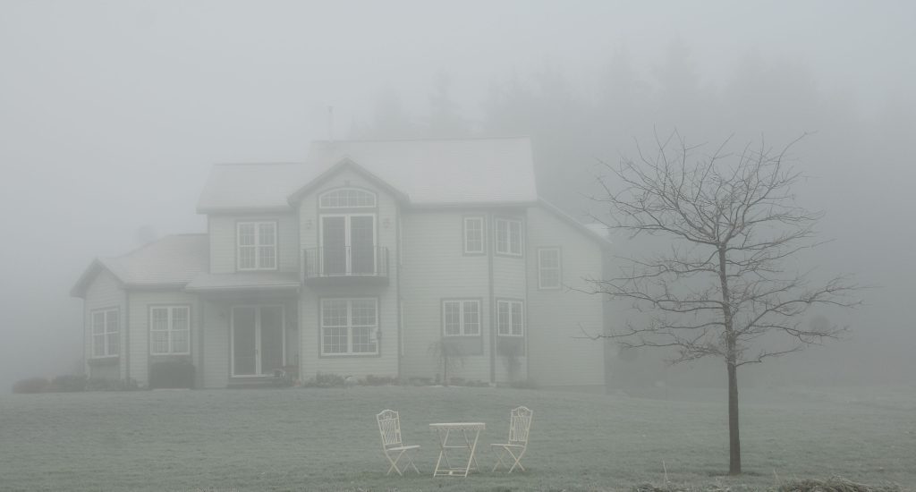 A spooky house surrounded by fog