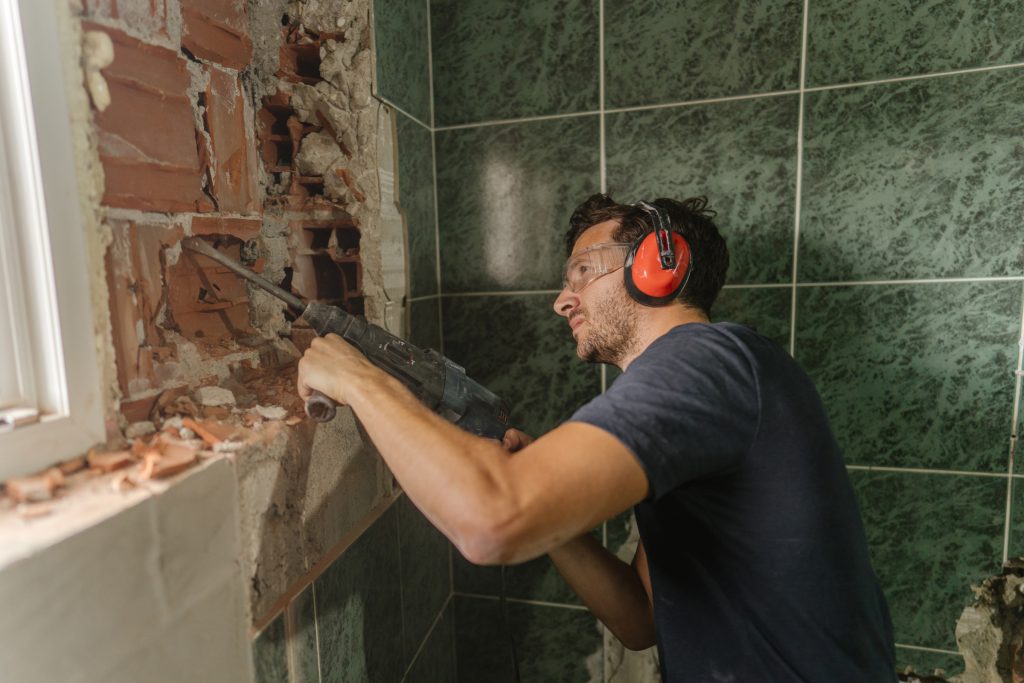 Restoration worker doing DIY work on a shower in Manor