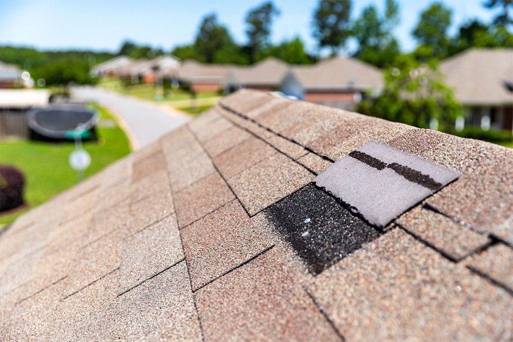 Damaged shingles on a roof causing a roof leak