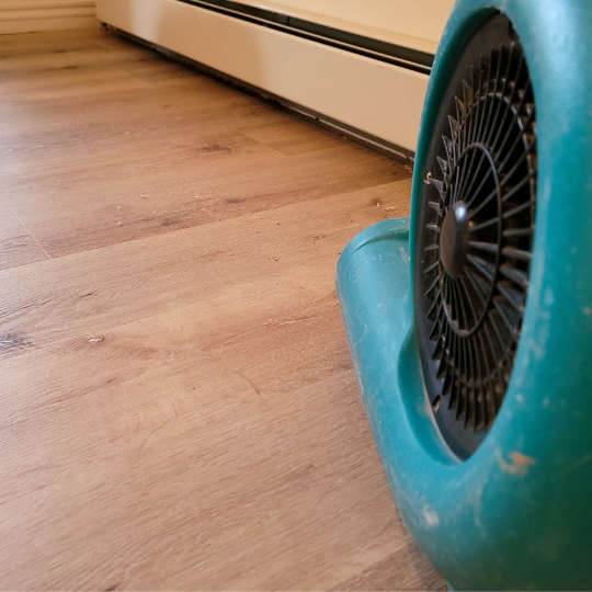 fan moving air to dry out floors after water damage