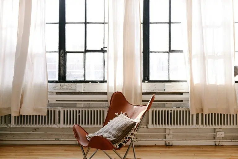 chair in apartment with space heaters behind it