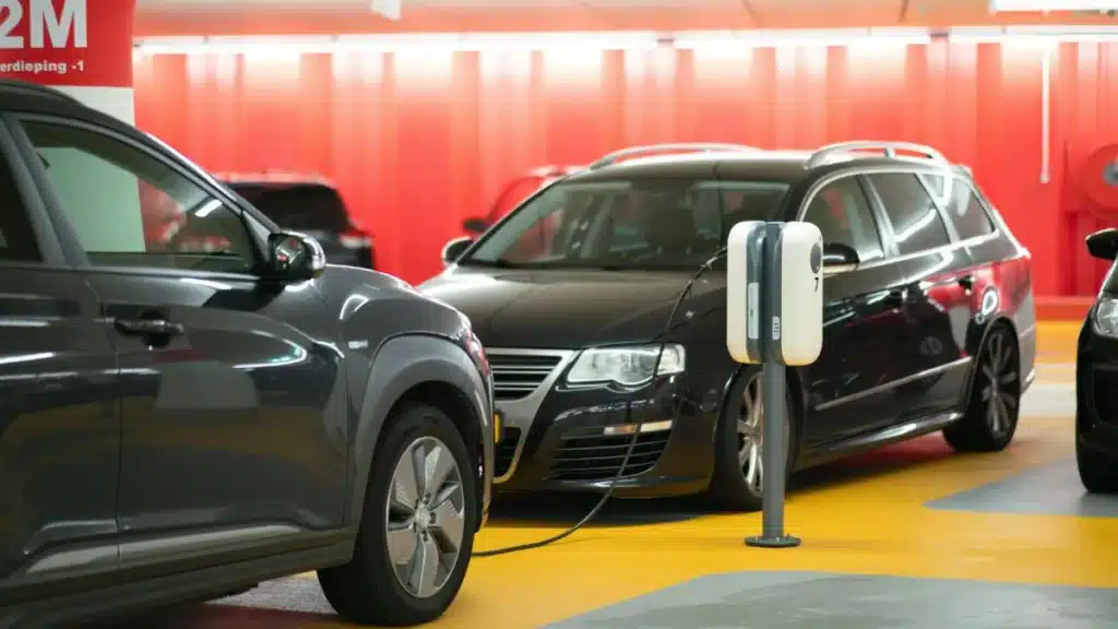 Electric cars plugged into a Level 2 charging station in a garage