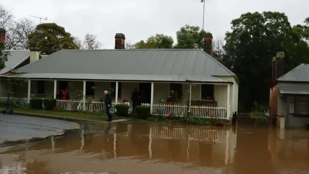 Single-story house surrounded by floodwater after heavy rain