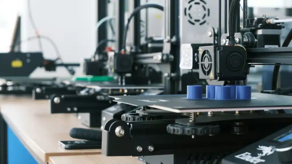 Row of FDM 3D printers running on a workbench